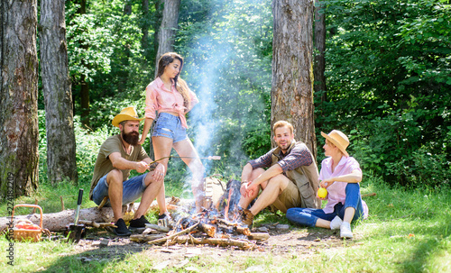 Friends enjoy summer vacation or weekend forest. Company friends relaxing near campfire. Summer vacation. Best friends spend leisure weekend forest nature background. Pleasant weekend near campfire