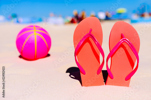 Flip flops  beach balll on the sandy beach. Summer vacation concept