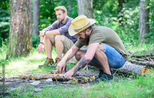 Camping in forest. How to build bonfire outdoors. Men on vacation. Man brutal bearded hipster prepares bonfire in forest. Ultimate guide to bonfires. Arrange the woods twigs or wood sticks