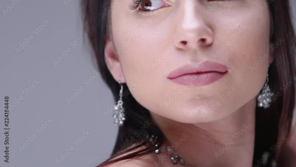Beautiful woman posing in studio. She shows women's jewelry Beautiful woman posing in studio. She shows women's jewelry