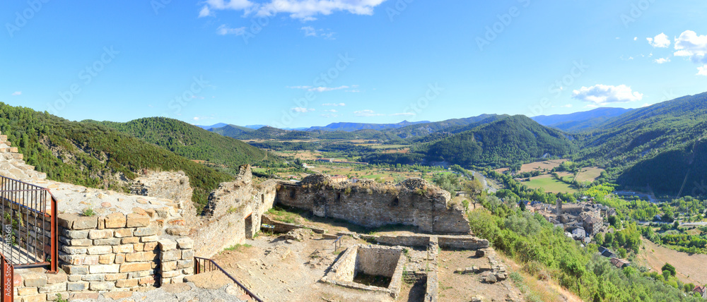 A landscape of cultivated fields, dense forest and mountains as seen from the ruins of the abandoned castle in the rural medieval town of Boltaña, in the Spanish Aragonese Pyrenees