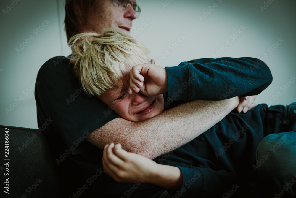 Fototapeta premium father comforting stressed crying sad son, parenting