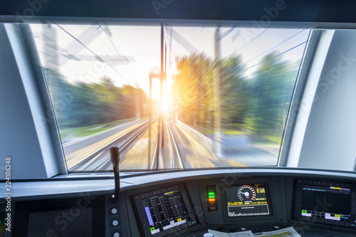 Driver's cab of speed passenger train, view of the railway bridge with the effect of speed motion blur.
