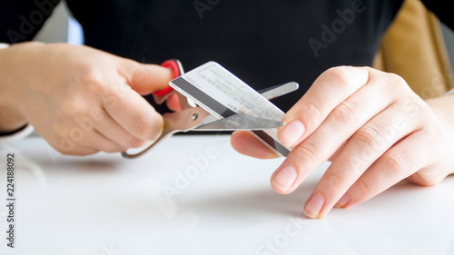 Closeup image of bank female worker cutting expired credti card with scissors