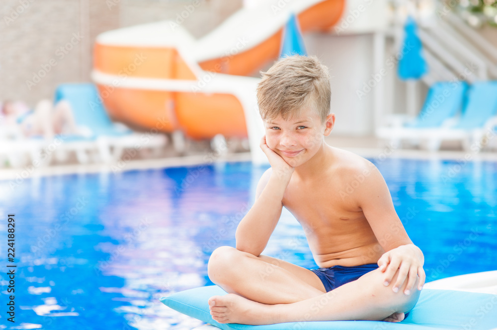 happy young boy by the pool. Relaxation resting vacations concept