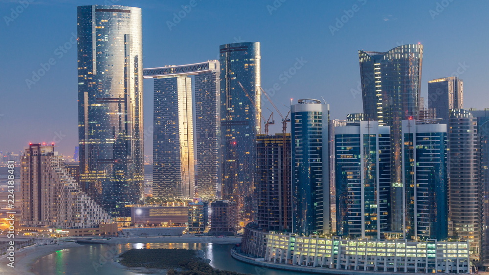 Obraz premium Buildings on Al Reem island in Abu Dhabi day to night timelapse from above.