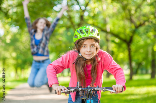 happy mother rejoices that her daughter learned to ride a bike