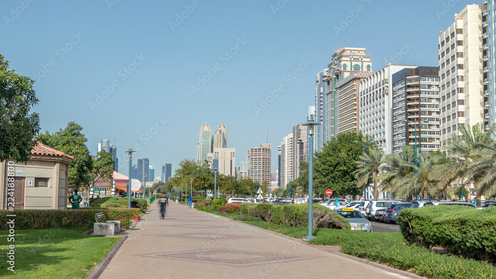 Corniche boulevard beach park along the coastline in Abu Dhabi timelapse with skyscrapers on background. Corniche boulevard beach park along the coastline in Abu Dhabi timelapse with skyscrapers on background.