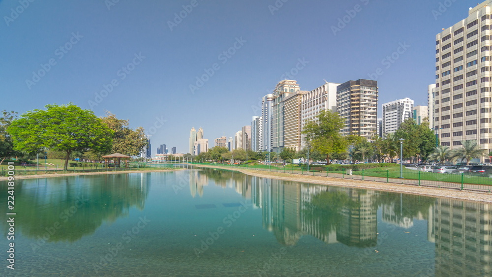 Corniche boulevard beach park along the coastline in Abu Dhabi timelapse hyperlapse with skyscrapers on background.