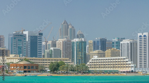 Modern buildings in Abu Dhabi skyline timelapse with mall and beach.