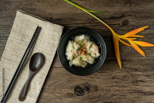 Shrimp wonton with braised pork in soup on wooden table - Asian food style  / Select focus image photo