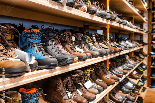 Many pairs of hiking, trekking and mountaineering boots for sale at travel shop