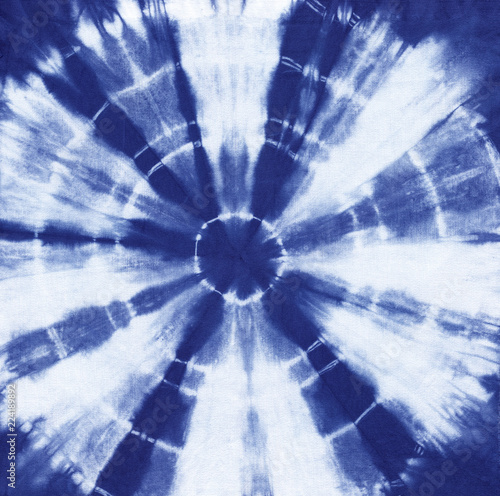 Фотография Abstract tie dyed fabric of indigo color on white cotton