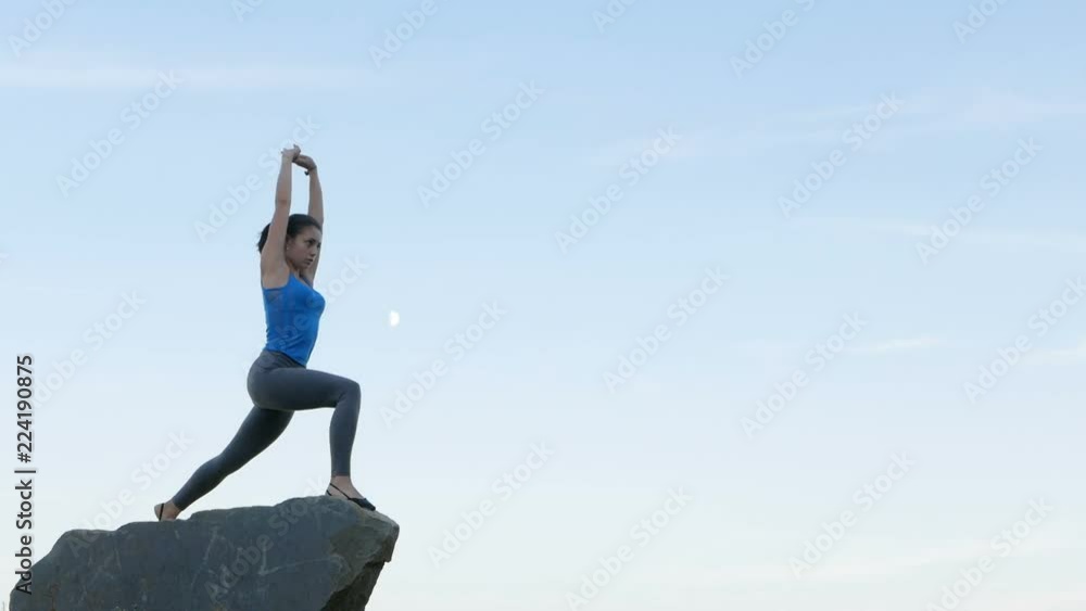 Happy young woman practicing yoga on the river rocks at sunset. Healthy active lifestyle concept. Slow Motion Happy young woman practicing yoga on the river rocks at sunset. Healthy active lifestyle concept. Slow Motion