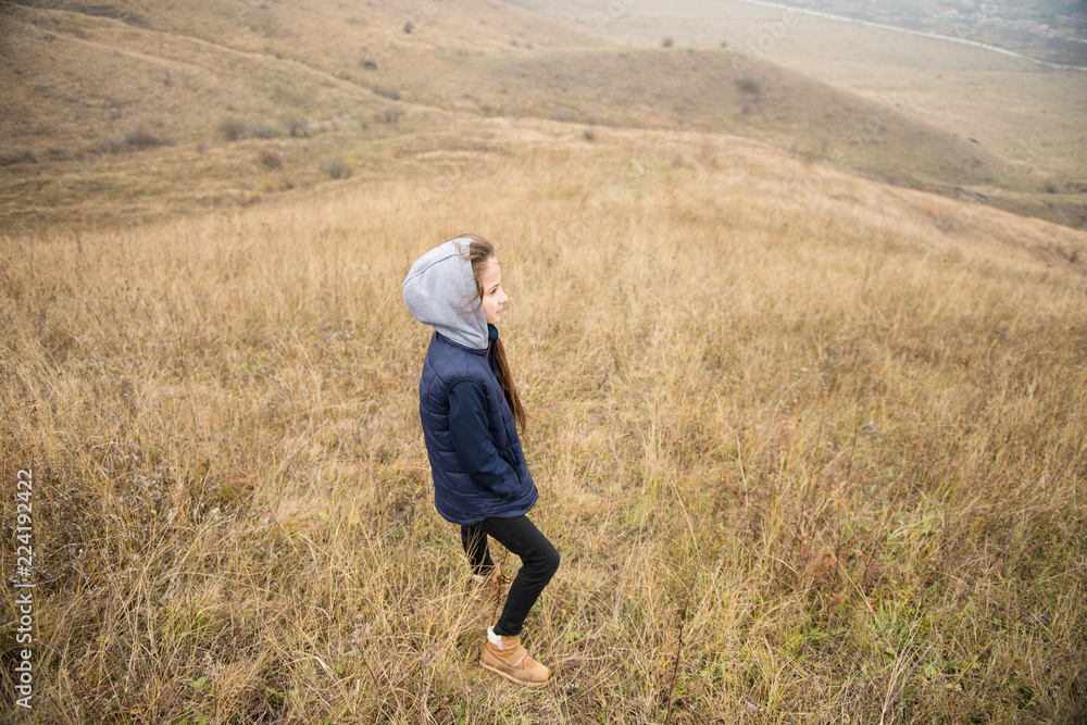 sport cute caucasian little girl in jacket with hood in windy mountains during hiking sport cute caucasian little girl in jacket with hood in windy mountains during hiking