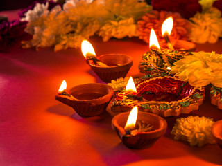 Colorful traditional clay diya lamps and flowers, with selective focus.