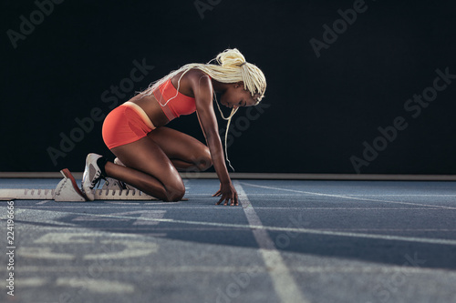 Sprinter using a starting block to start her sprint on a running
