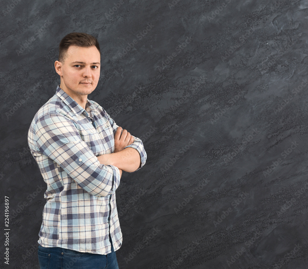 Young man with crossed arms over gray background