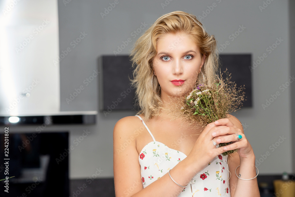 Naklejka premium portrait of beautiful young blonde woman with bouquet of flowers