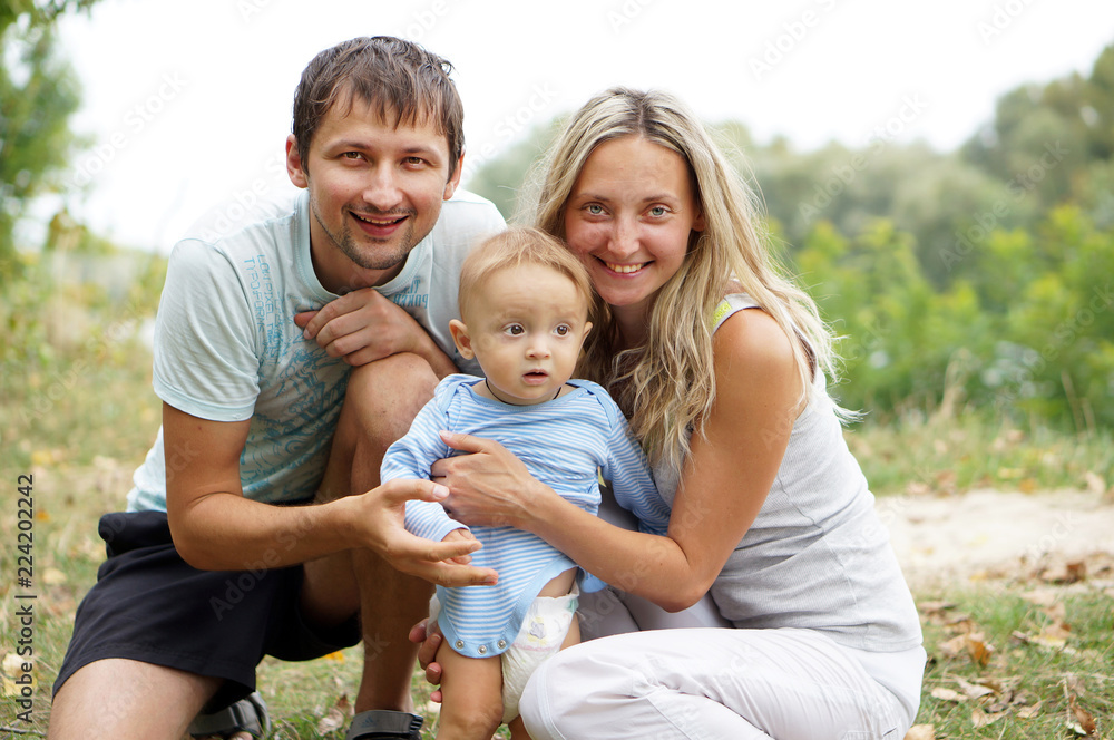 Smiling parents with baby boy in the park Smiling parents with baby boy in the park