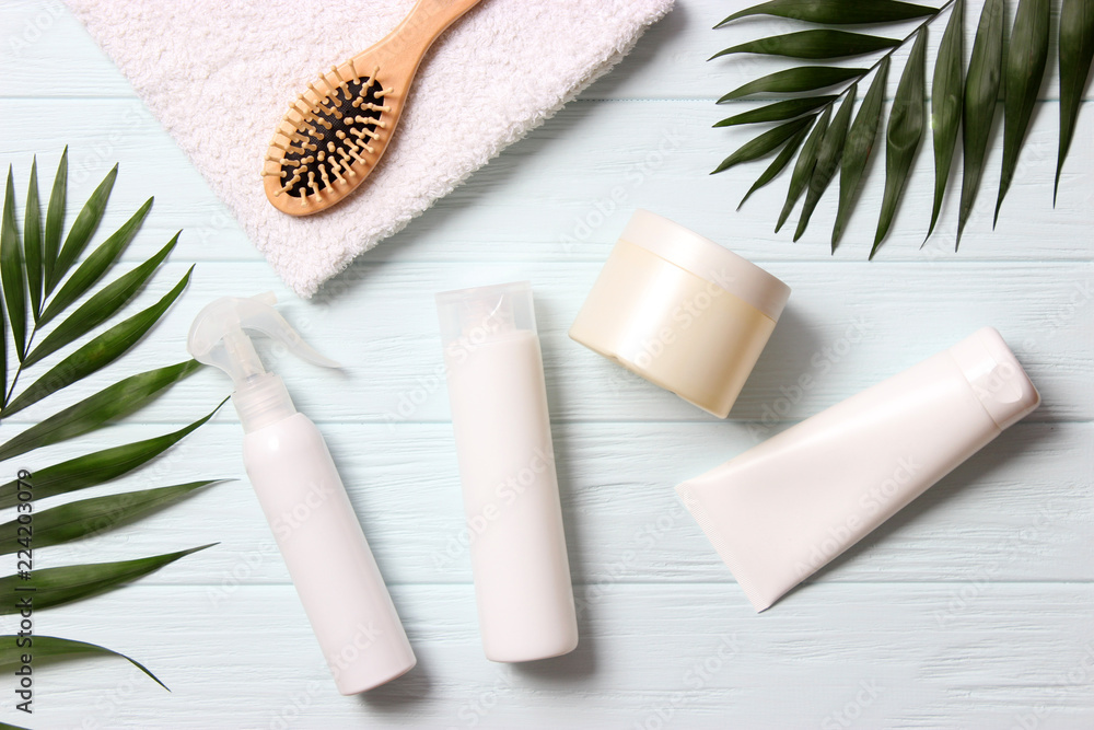 natural hair care products, hairbrush, towel and leaves on a wooden background top view. Shampoo, mask, balm. flatlay