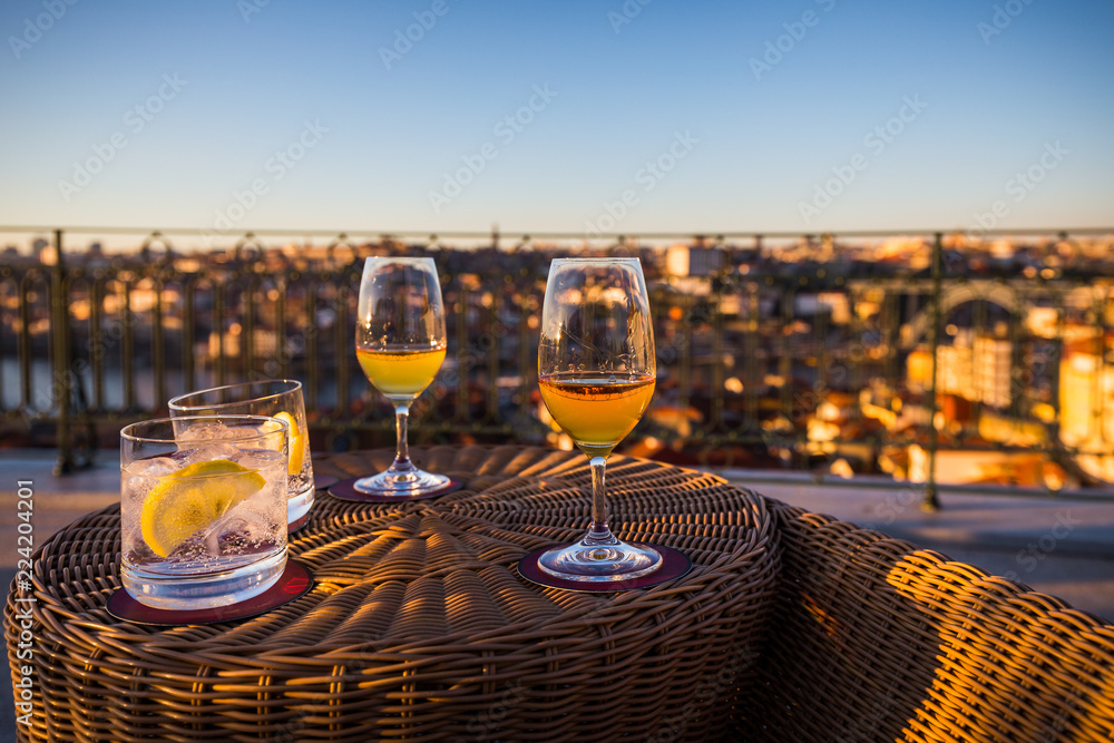 Two glasses of Porto (Port wine) in warm evening light with blurry view of the city Porto in the background