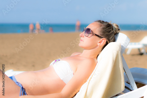 Girl are lying on the beach in sunglasses