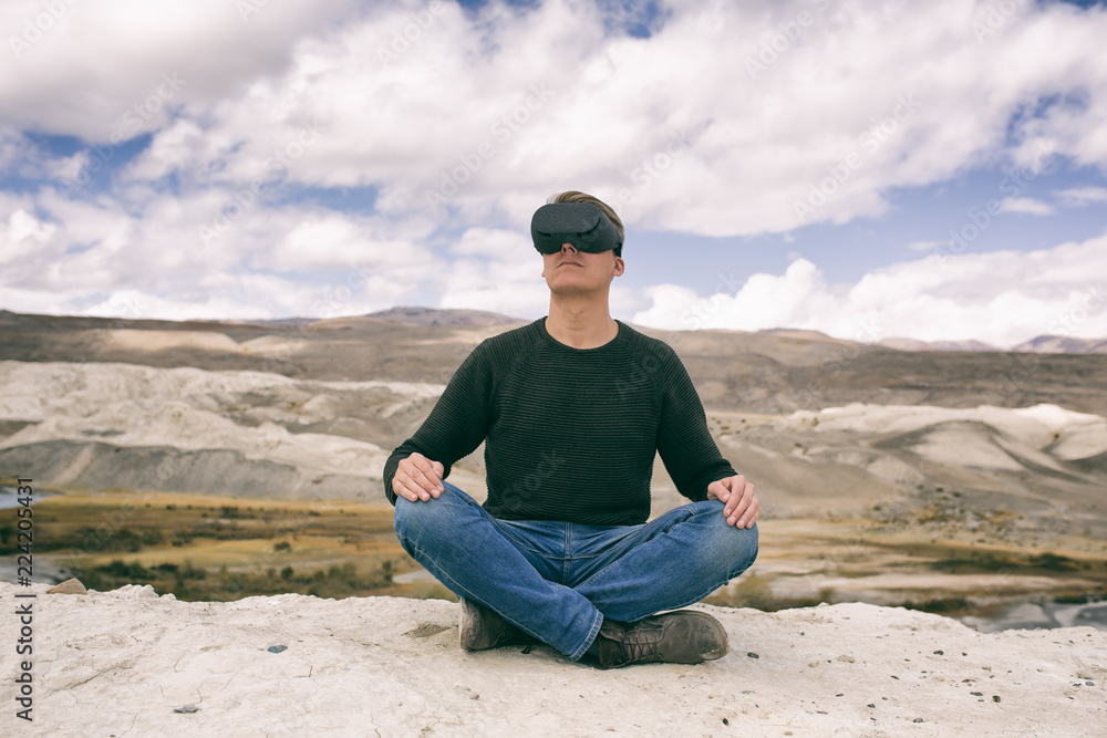 man in glasses of virtual reality meditates against the background of nature. The man in the game.