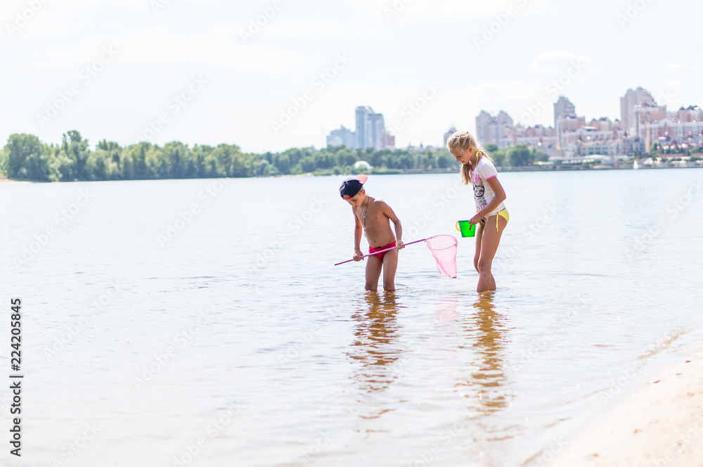 Children fishing in a river with a net