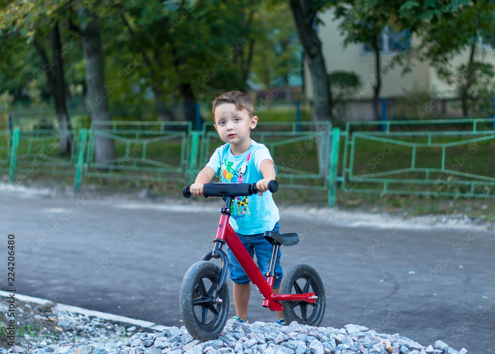 Funny active little boy riding on bicycle on warm summer day. Countryside. Active leisure and Funny active little boy riding on bicycle on warm summer day. Countryside. Active leisure and