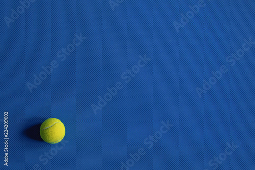 Yellow tennis ball on the blue background © Andrey Tarakanov