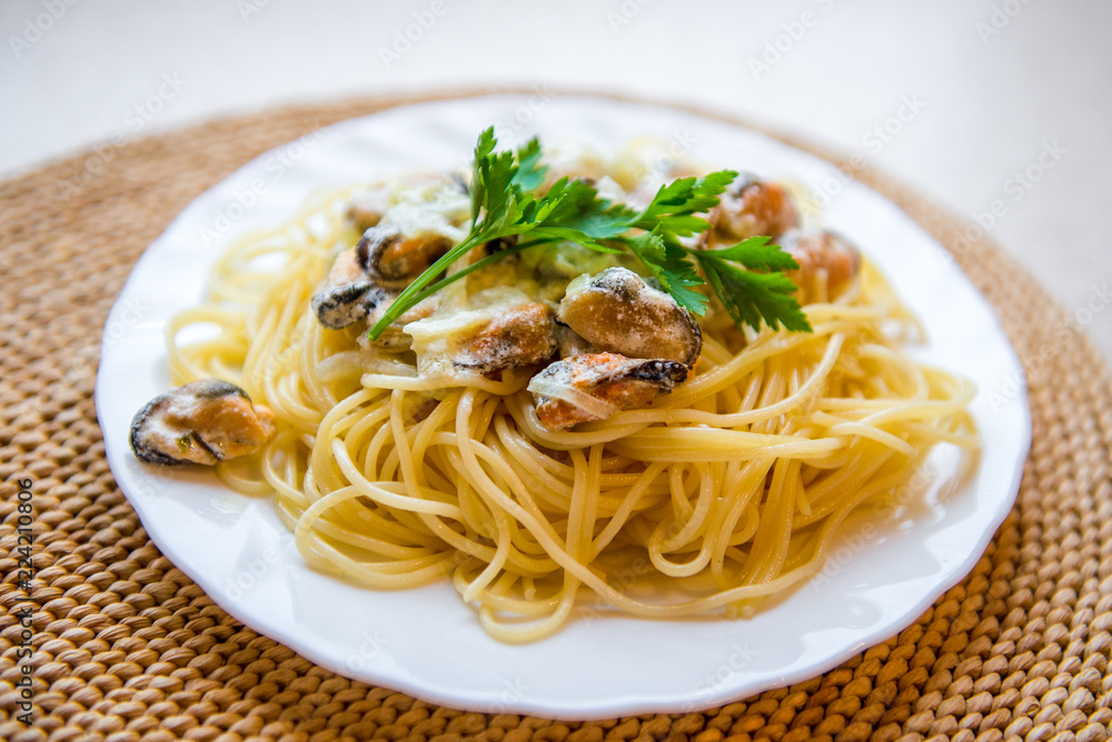 Traditional italian seafood pasta with clams. Spaghetti with mussels in creamy sauce Traditional italian seafood pasta with clams. Spaghetti with mussels in creamy sauce