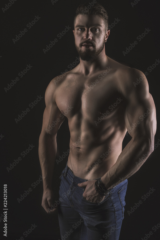 Athletic Strong Sexual Man Abs Six Pack Muscles Bodybuilding And Fitness Concept. Studio shot, Low key, copy space on black background Athletic Strong Sexual Man Abs Six Pack Muscles Bodybuilding And Fitness Concept. Studio shot, Low key, copy space on black background