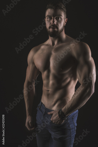 Athletic Strong Sexual Man Abs Six Pack Muscles Bodybuilding And Fitness Concept. Studio shot, Low key, copy space on black background