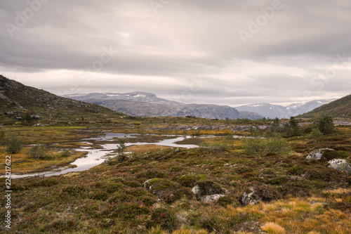 rugged wild mountain landscape in norway cloudy and calm river