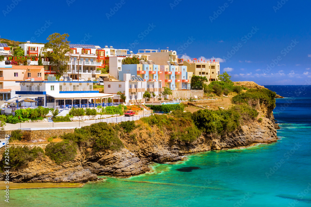 Varkotopos beach in sea bay of resort village Bali. Views of shore, washed by waves. Greek houses stand on the rocky shore. Crete, Greece