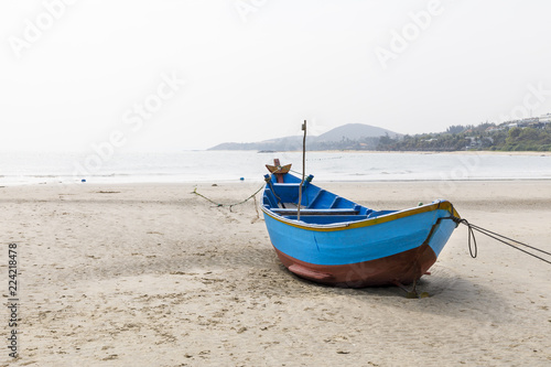 Blue fishing boat on sandy beach in Vietnam