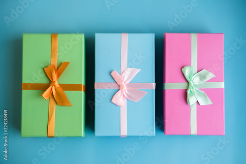 Festive holiday New Year and Christmas blue background with colorful gift boxes. Concept of carnival, birthday, party. Flat lay. Top view.
