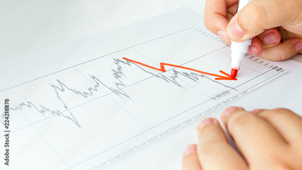 Closeup image of business analyst drawing decreasing graph on stock sales chart Closeup image of business analyst drawing decreasing graph on stock sales chart