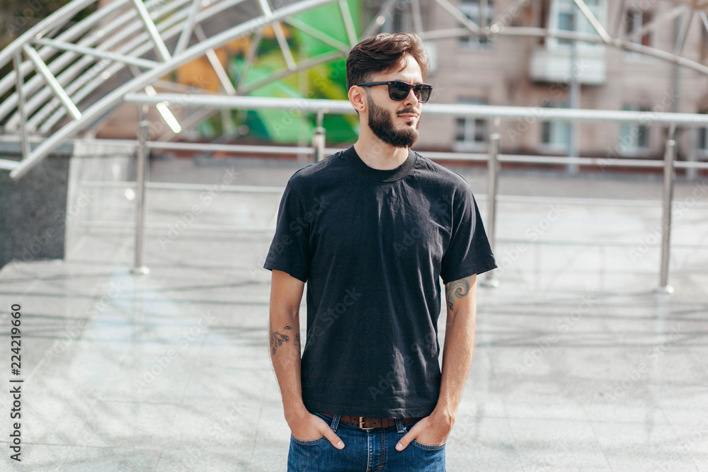 A stylish man with a beard with a black T-shirt. Street photo A stylish man with a beard with a black T-shirt. Street photo