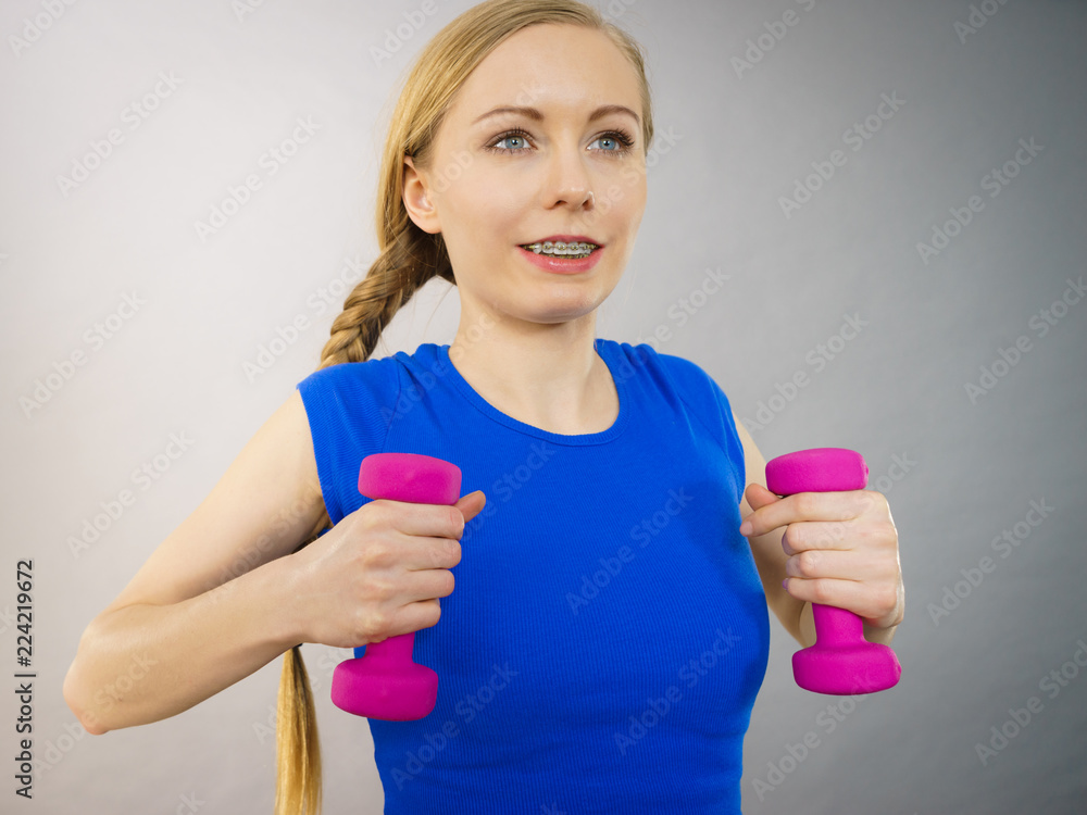 Teenage woman working out at home with dumbbell Teenage woman working out at home with dumbbell