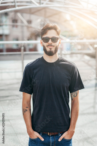 A stylish man with a beard with a black T-shirt. Street photo