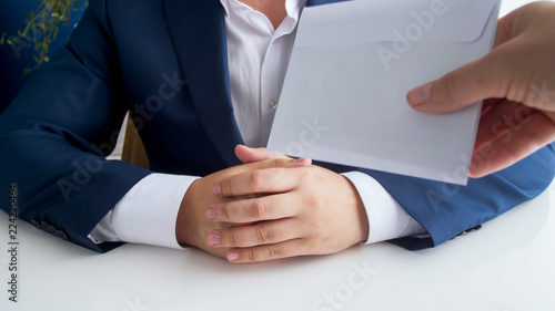 Closeup photo of person giving envelope to corrupted politician in office