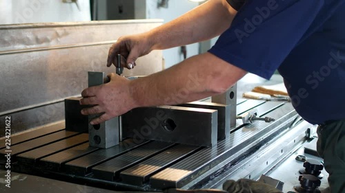 Male specialist borer fixes a metal pulley on a reaming machine, small business, workroom, gin photo