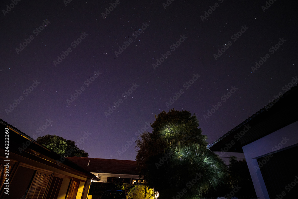 Starry sky above house roof