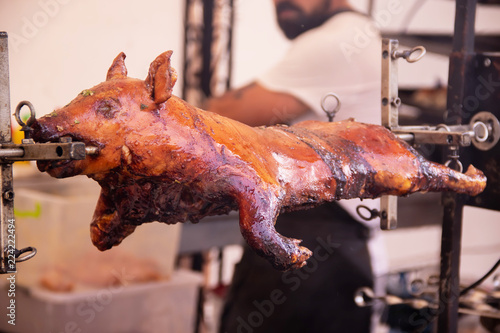 Grilled pig on spit street food festival