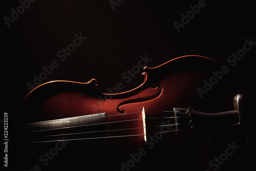 Fototapeta part of a violin on a black background with hard light