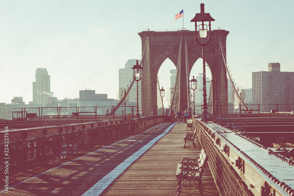 Naklejka premium Brooklyn Bridge w Nowym Jorku. Sławny punkt zwrotny w usa przy ranku światłem.