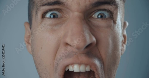Close-up face of angry man screaming against white background. photo