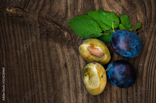 Fresh blue plums on wood table background. Sweet autumn fruit. Delicious and healthy raw food full of vitamins.